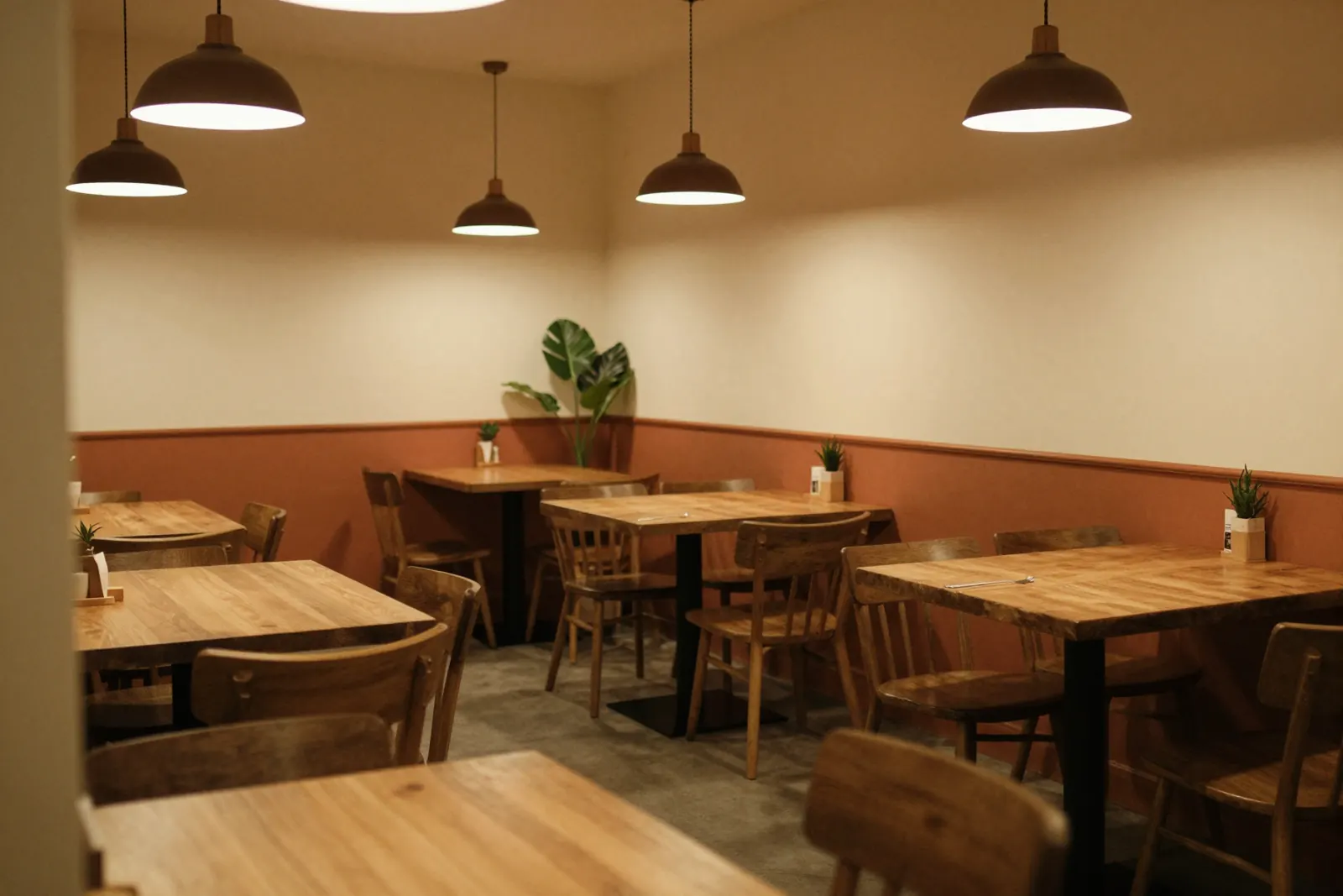 The dining room in the evening: wooden tables and low pendant lamps